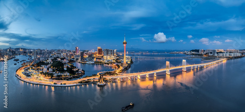 Photography Night aerial panorama of Macau skyline and illuminated bridge crossing the water at twilight, China