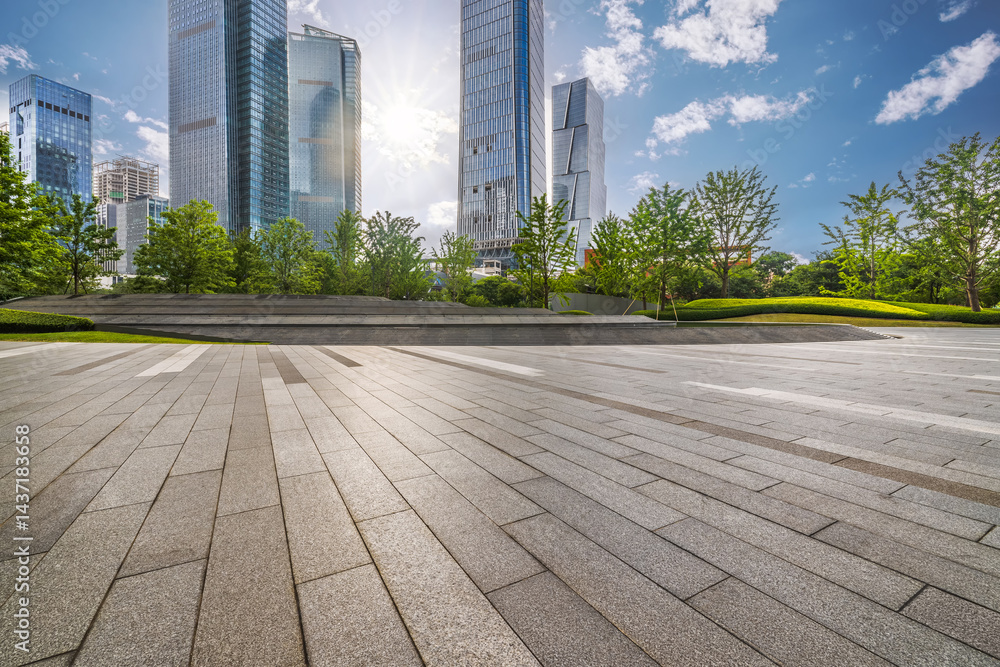 Fototapeta premium Empty stone tiled floor and modern glass office skyscrapers in city.