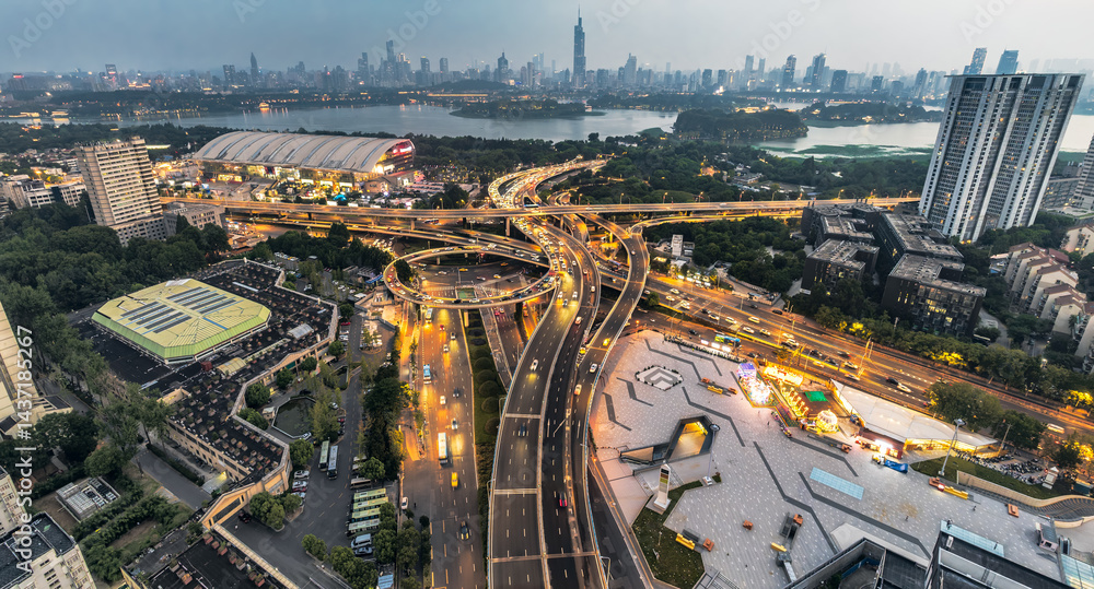 Fototapeta premium Panoramic of modern cityscape featuring complex road interchange and illuminated skyline at dusk in Nanjing, China.