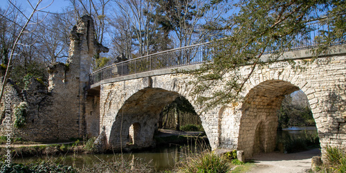 old stone ancient bridge medieval over lake river in Blanquefort France with water reflection
