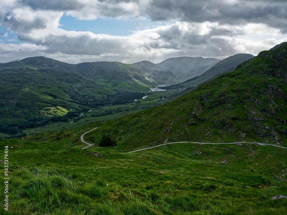 Discover the charm of Ireland's natural beauty in this photo. Gentle slopes and a twisting path create a picturesque landscape. Discover the charm of Ireland's natural beauty in this photo. Gentle slopes and a twisting path create a picturesque landscape.