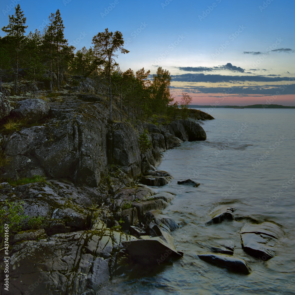 Sunset at stony shore of Ladoga lake