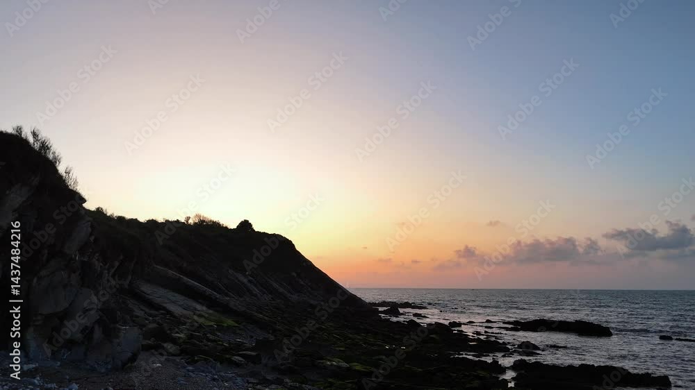 Roche côtière et coucher du soleil vu en traveling droit, sur la côte basque près d'Hendaye, format paysage 16:9 Baie de Txingudi Roche côtière et coucher du soleil vu en traveling droit, sur la côte basque près d'Hendaye, format paysage 16:9 Baie de Txingudi