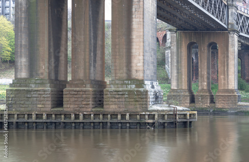 Obraz na płótnie Foundation pillars abutment and Steel truss construction of The King Edward VII Bridge (Railway viaduct) is a railway bridge spanning the River Tyne between Newcastle upon tyne and Gateshead in Eng. w salonie