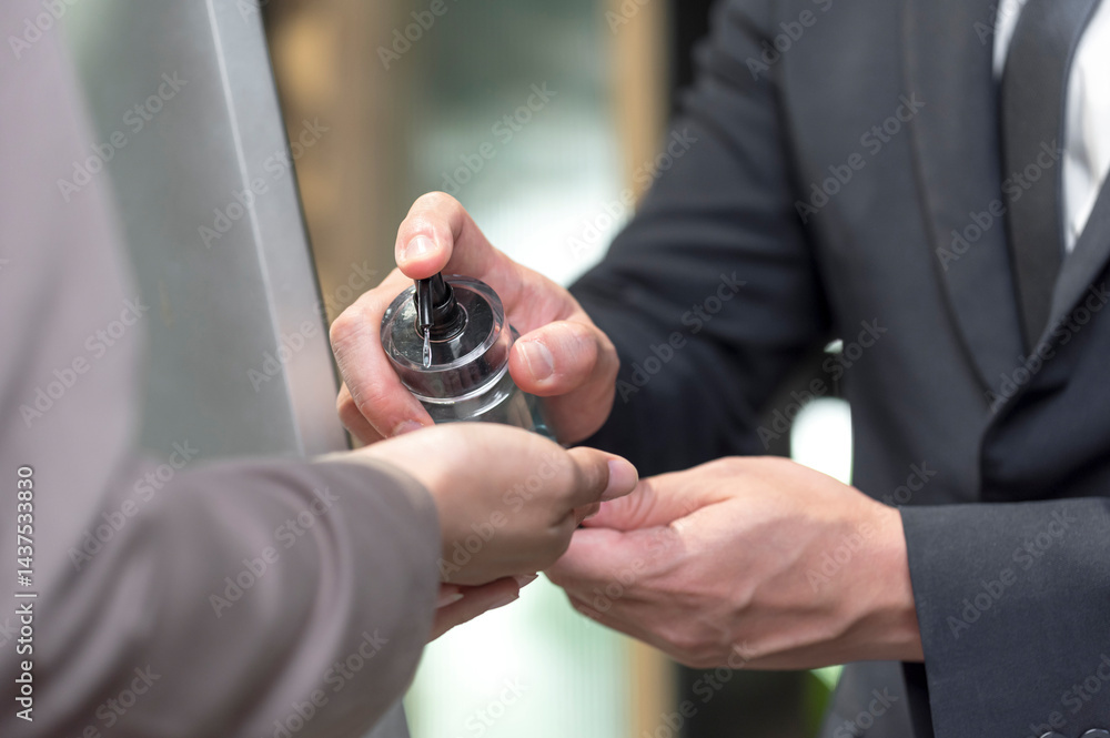 cleaning hand with alcohol sanitizer gel at entrance office
