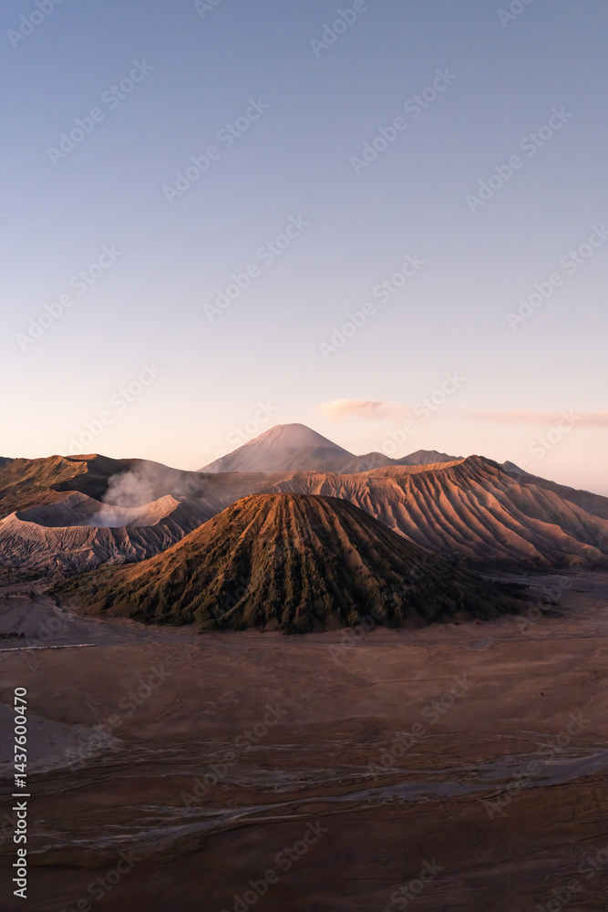 Fototapeta premium Scenic view of mount bromo emitting smoke at sunrise in east java, indonesia