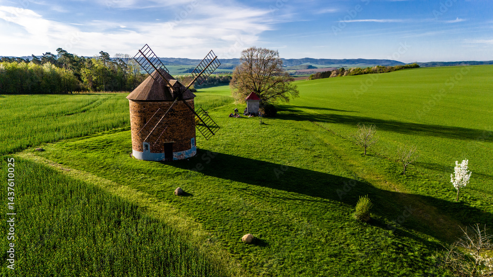 drone footage of historic windmill and blooming trees in czech countryside