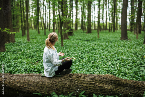 Obraz na płótnie Woman doing relaxation exercise and sitting in yoga lotus position in nature. Forest bathing and meditation w salonie