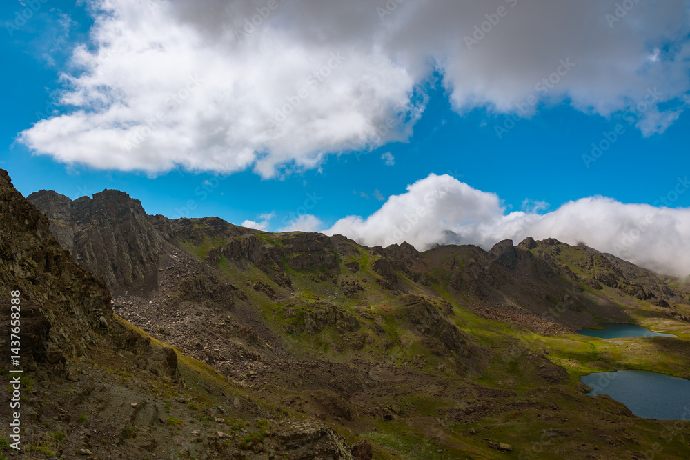 Mountain range with lake and partly cloudy sky on the background