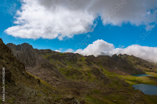 Obraz na płótnie Mountain range with lake and partly cloudy sky on the background w salonie