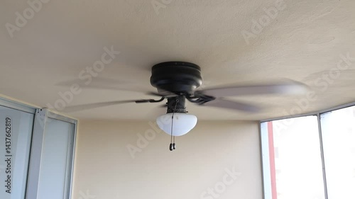 Ceiling fan slow spinning brown fin white lantern