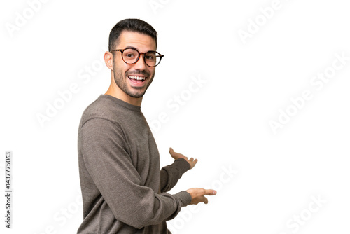 Young handsome caucasian man over isolated background extending hands to the side for inviting to come