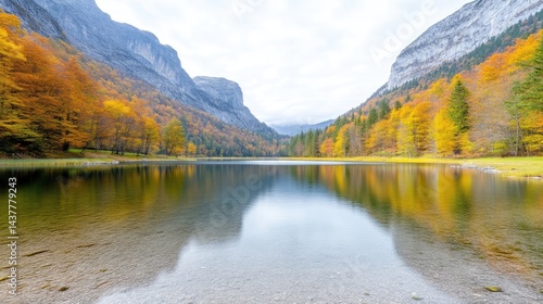 Autumnal lake nestled between majestic mountains.  Tranquil reflection of fall colors on a glassy lake surface photo
