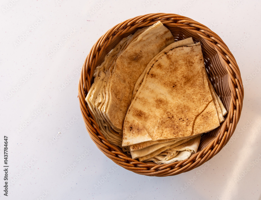 Traditional flatbread, lavash in basket, wheaten pita flat bread or flatbread also known as pita bread
