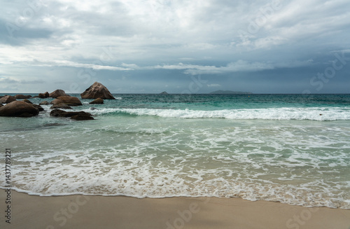 Obraz na płótnie Tropical beach with rocks and waves under stormy clouds on Seychelles island, ocean landscape w salonie