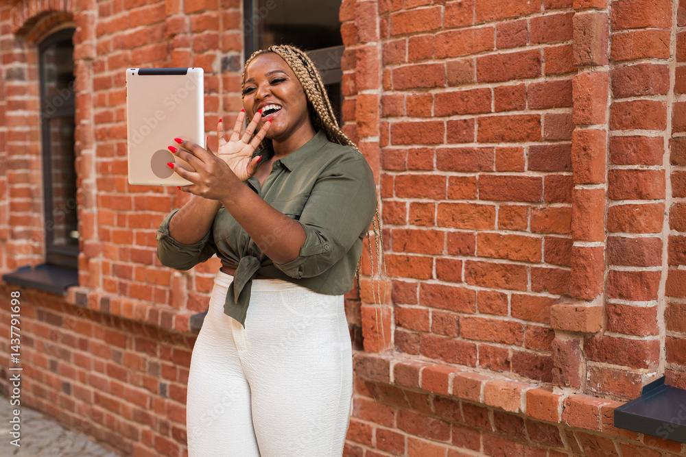 African american woman smiling and holding a tablet while walking on city. Communication, happiness, and digital connection with loved ones