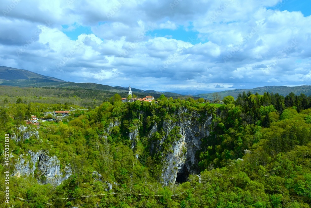 Beautiful view of Škocjan village at Velika dolina in Škocjan caves with a trail bellow and clouds in the sky in Kras, Primorska, Slovenia