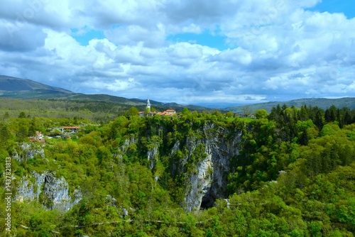 Obraz na płótnie Beautiful view of Škocjan village at Velika dolina in Škocjan caves with a trail bellow and clouds in the sky in Kras, Primorska, Slovenia w salonie