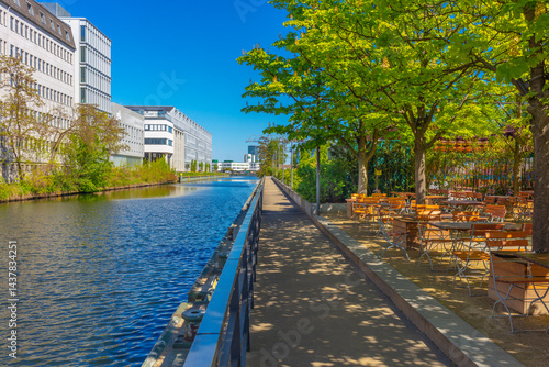 Berlin: Neugestaltung Uferbereich am Neuköllner Schifffahrtskanal im Bezirk Neukölln, Köllnische Heide: Blick Richtung Treptow, Neue Architektur am Kanalufer: New Campus University | Gastro Biergarten