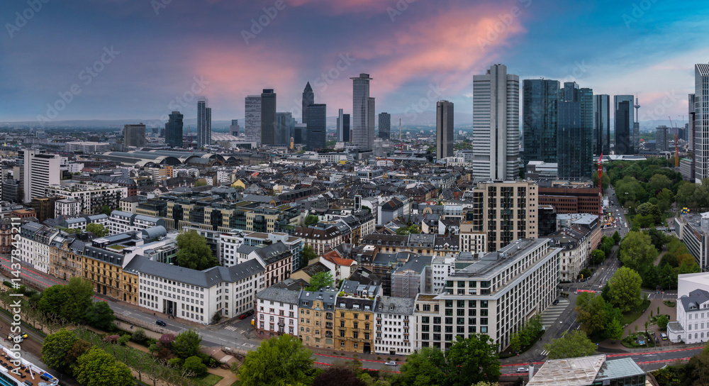Aerial view of Frankfurt, Germany, featuring the Commerzbank Tower, Main Tower, and Hauptbahnhof. Sunset colors highlight the mix of architecture.