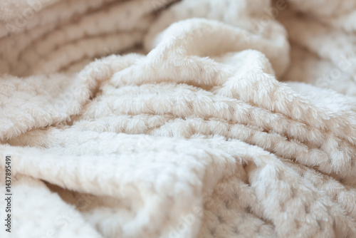 Cozy Comfort: A close-up of a soft, textured blanket, inviting warmth and relaxation, with its gentle folds and plush feel.