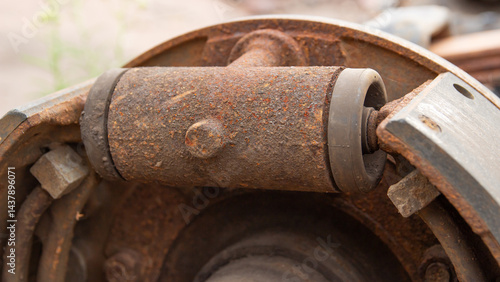 Close-up of a heavily rusted brake cylinder and brake shoe, components of a drum brake system.