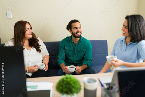 Obraz na płótnie Office workers enjoying a coffee break, chatting and smiling in the office w salonie