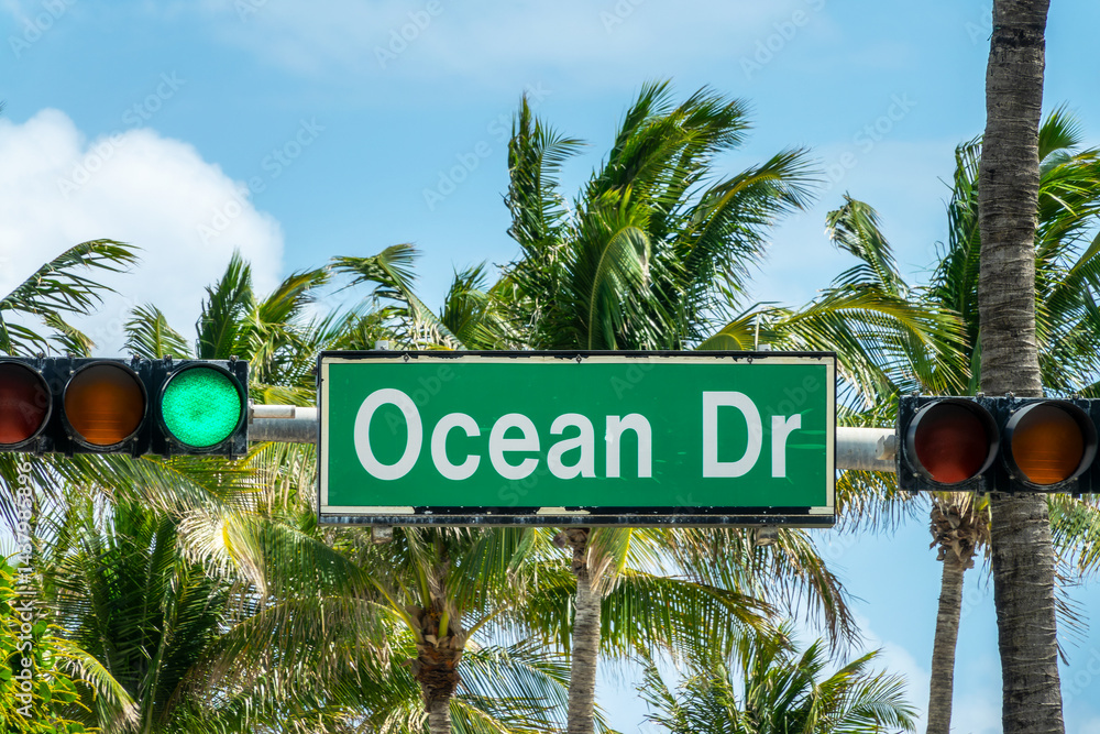 Ocean Drive street sign, traffic lights and palm trees in Miami Beach, Florida