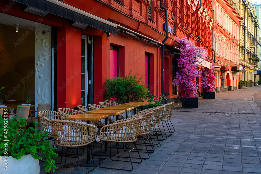Street with tables of cafe in center of Moscow in Russia. Cozy cityscape in Moscow. Architecture and landmarks of Moscow.