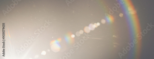 A strong lens flare with prominent curved rainbow refraction, scattering luminous effect on transparent background