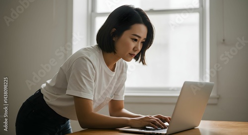 Young woman working on a laptop in the workroom
