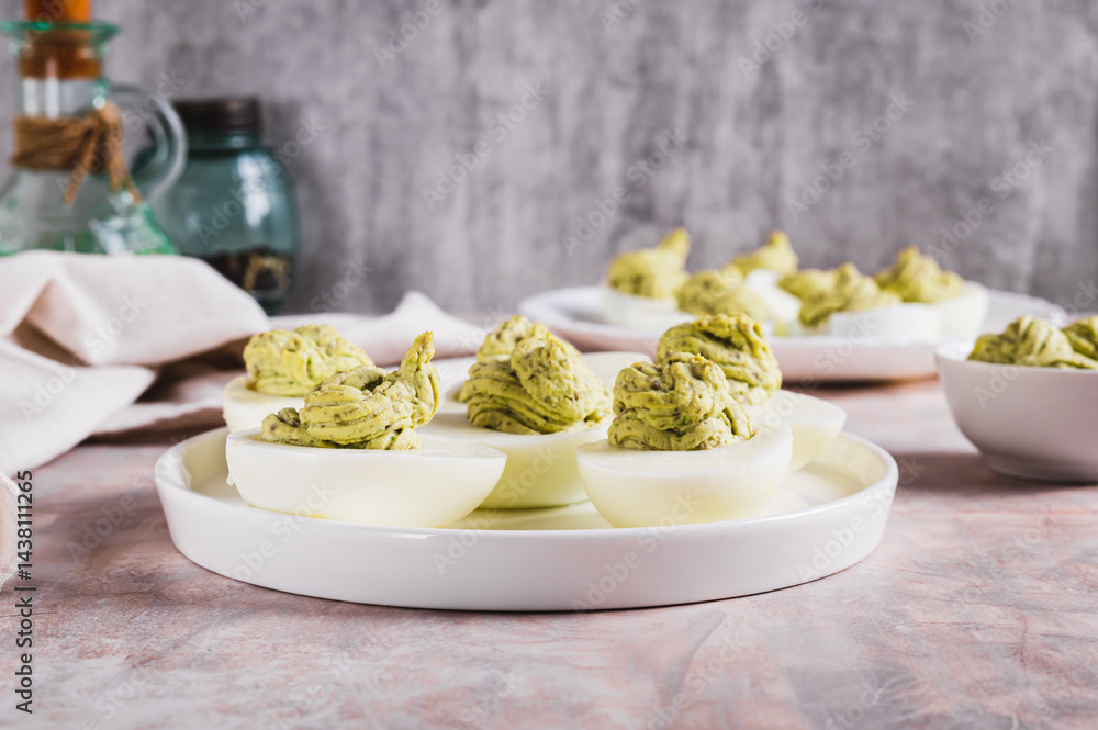 Eggs stuffed with avocado and yolk mixture on a plate on a table