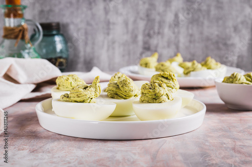 Obraz na płótnie Eggs stuffed with avocado and yolk mixture on a plate on a table w salonie