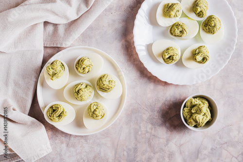 Obraz na płótnie Eggs stuffed with avocado and yolk mixture on a plate on a table top view w salonie