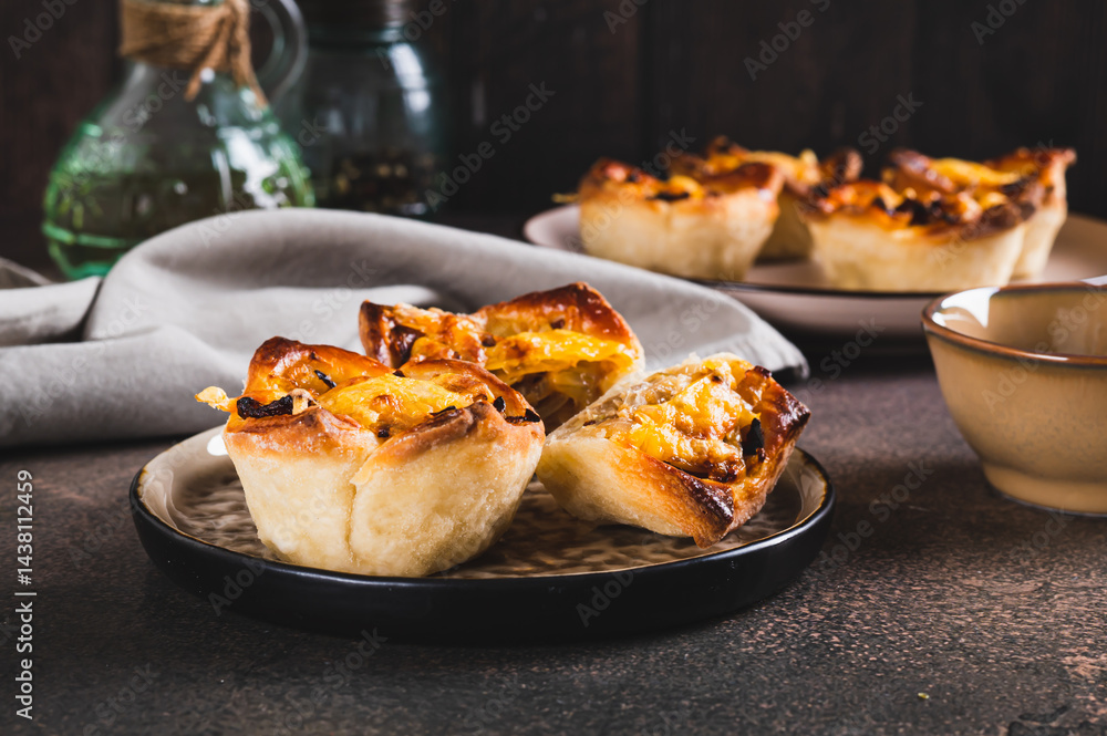 Mini tartlets with caramelized onions and cheese on a plate on a table