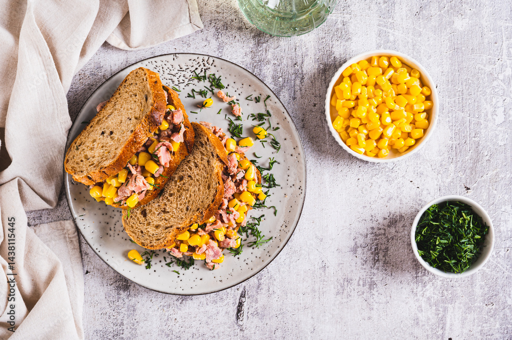 Delicious sandwiches with tuna, corn and greens on grain bread top view