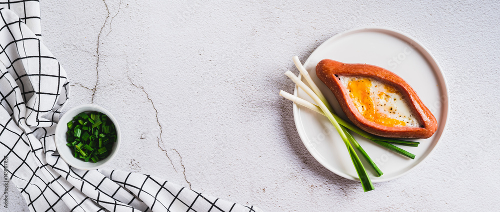 Sausage filled with fried egg and garlic on a plate on a table top view web banner