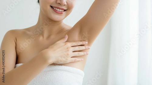 Smiling woman showing underarm in a bright, serene bathroom  