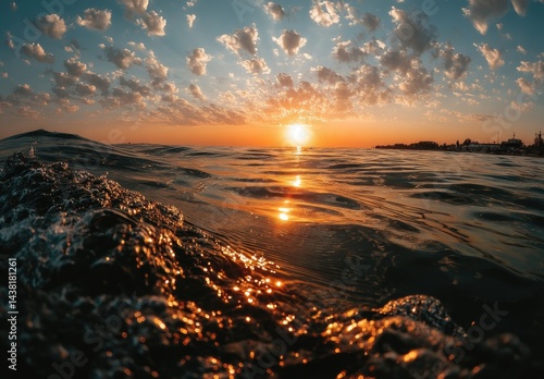 A sunset over the ocean with the sun setting in the distance