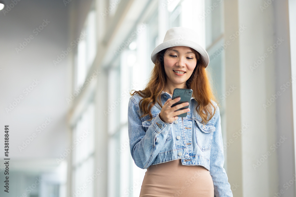 Happy Female Travelling use smartphone. Happy asian woman passenger traveler waiting for departure with suitcase at modern airport terminal
