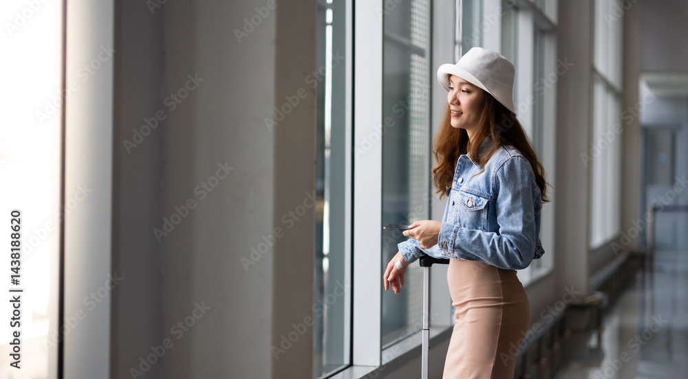 Happy Female Travelling use smartphone. Happy asian woman passenger traveler waiting for departure with suitcase at modern airport terminal