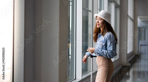 Obraz na płótnie Happy Female Travelling use smartphone. Happy asian woman passenger traveler waiting for departure with suitcase at modern airport terminal w salonie