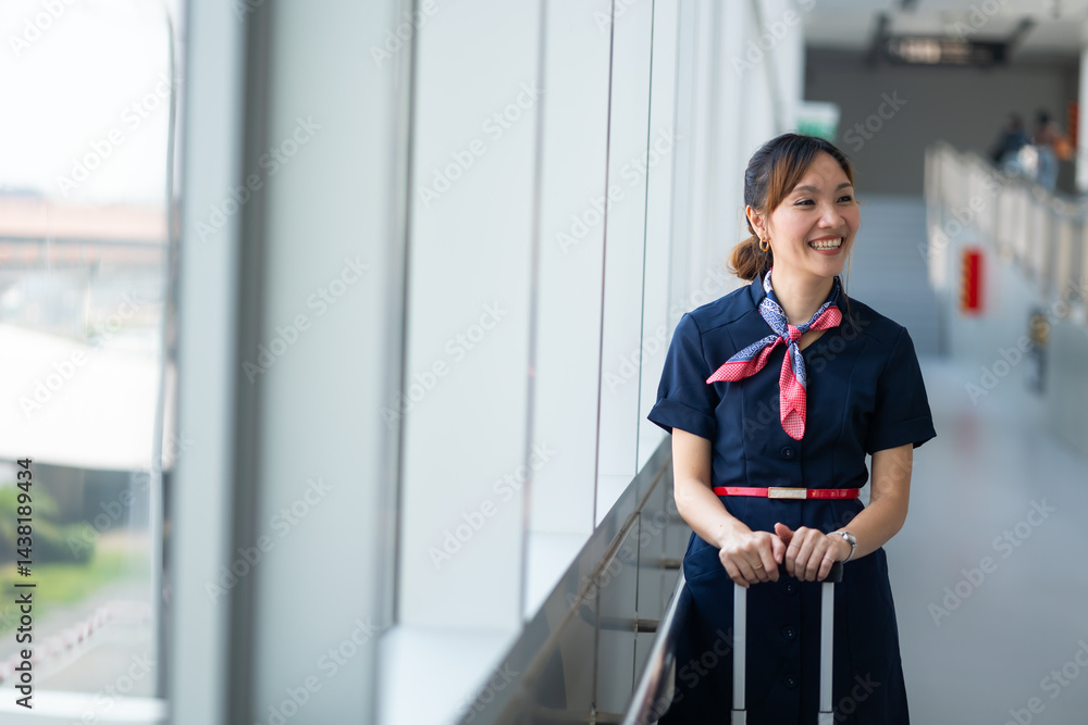 Portrait female Cabin crew or air hostess in airport. Cabin crew, air hostess working in airplane. Service mind. Asian stewardess with suitcase at modern airport terminal. flight attendant