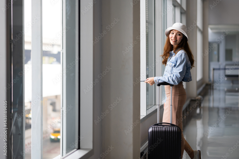 Portrait Happy Asian Female traveler passenger with luggage. Happy Asian beautiful woman passenger traveler waiting for departure with suitcase at modern airport terminal