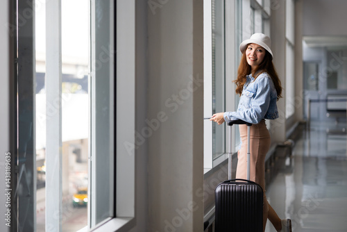 Obraz na płótnie Portrait Happy Asian Female traveler passenger with luggage. Happy Asian beautiful woman passenger traveler waiting for departure with suitcase at modern airport terminal w salonie