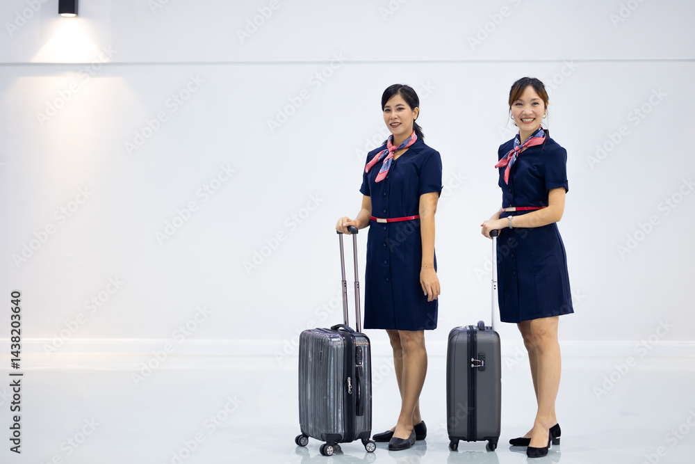 Portrait two Cabin crew or air hostess in airport. Cabin crew, air hostess working in airplane. Service mind. Asian stewardess with suitcase at modern airport terminal. flight attendant