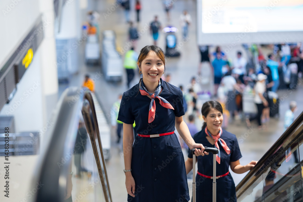 Back view two Cabin crew or air hostess in airport. Cabin crew, air hostess working in airplane. Service mind. Asian stewardess with suitcase at modern airport terminal. flight attendant