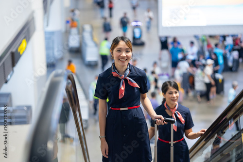 Back view two Cabin crew or air hostess in airport. Cabin crew, air hostess working in airplane. Service mind. Asian stewardess with suitcase at modern airport terminal. flight attendant
