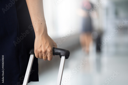 Obraz na płótnie Closeup hand woman Walking in airport. Cabin crew, air hostess working in airplane. Service mind. Asian stewardess with suitcase at modern airport terminal. flight attendant w salonie