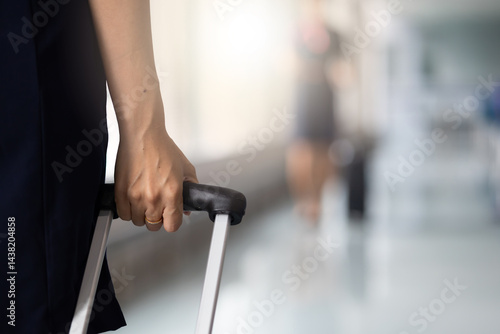 Obraz na płótnie Closeup hand woman Walking in airport. Cabin crew, air hostess working in airplane. Service mind. Asian stewardess with suitcase at modern airport terminal. flight attendant w salonie